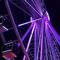 a ferris wheel in the dark, lit in purple