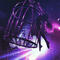a circus acrobat bathed in purple lighting
